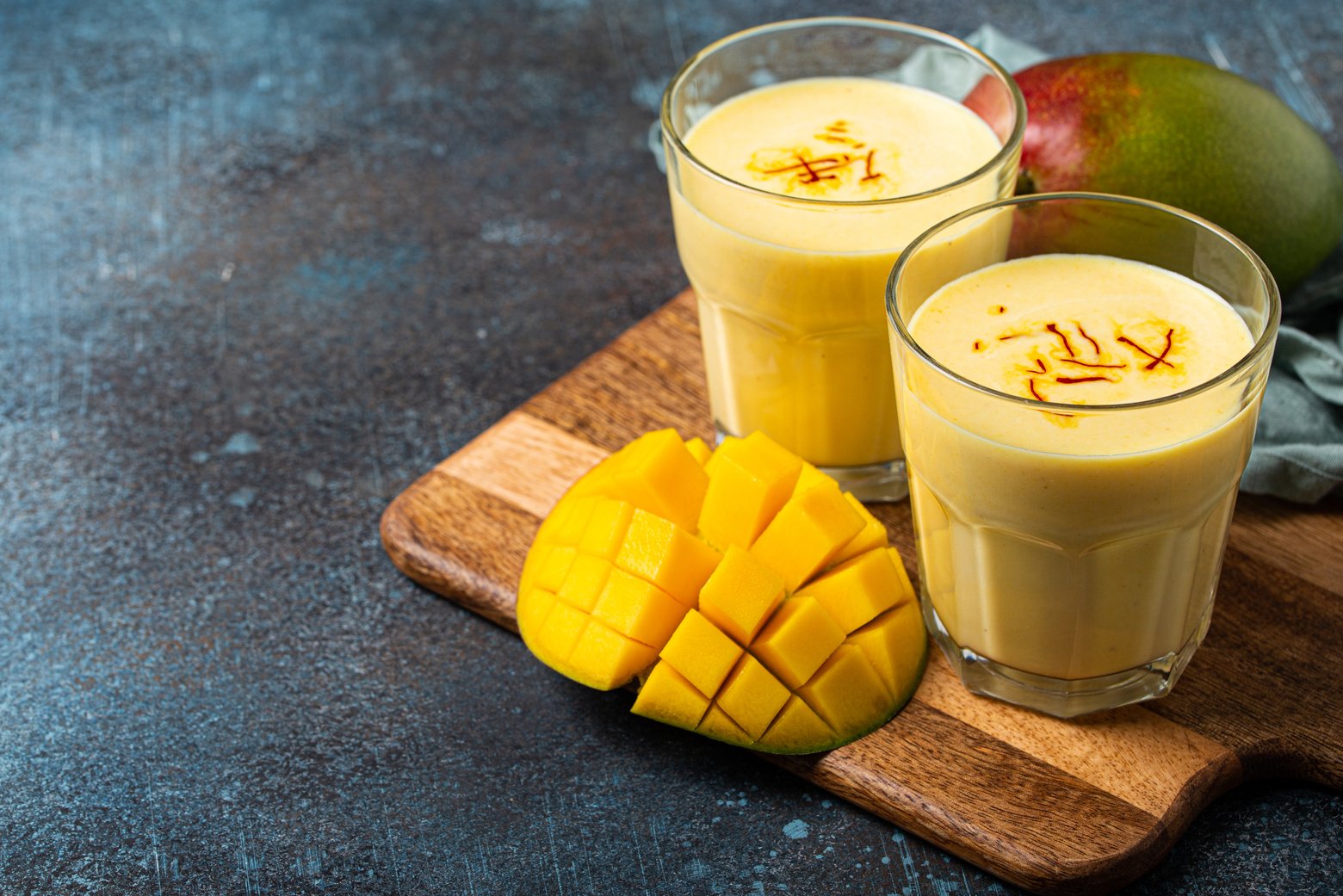 Drink Mango Lassi in Two Glasses on Rustic Concrete Table with F